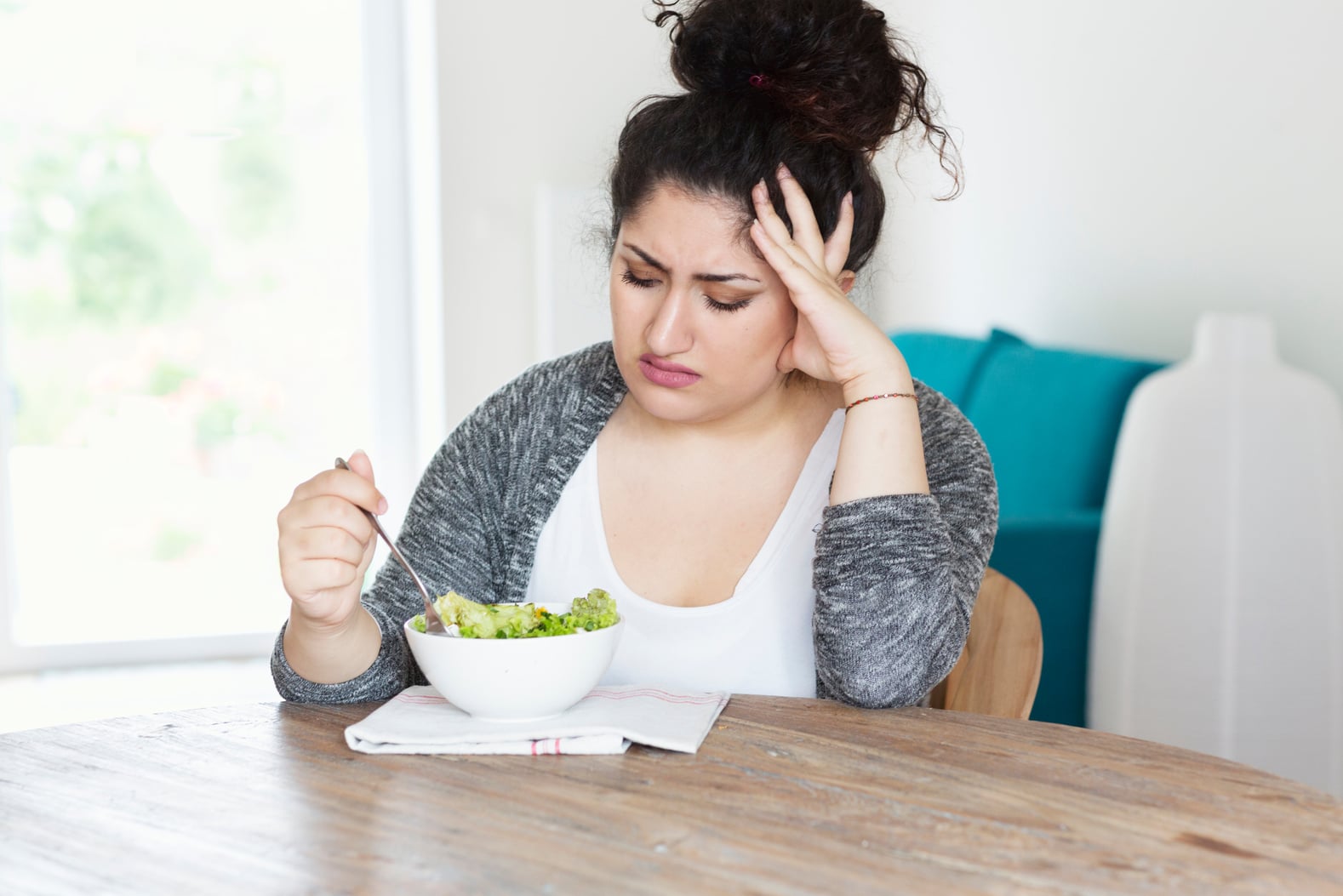 young hispanic woman diet eating salad unhappy